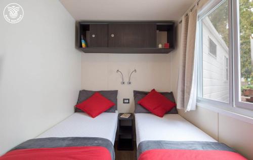 two beds in a small room with a window at Centro Turistico San Nicola in Peschici