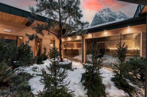 a house in the snow with a mountain at Hotel Majon Miramonti in Canazei
