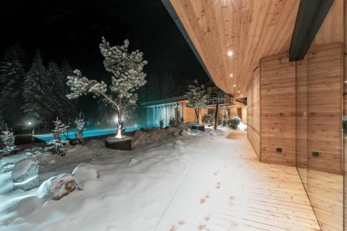 a house in the snow at night at Hotel Majon Miramonti in Canazei