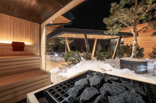 a sauna with a fire pit in the snow at Hotel Majon Miramonti in Canazei