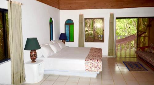 a bedroom with a white bed and a window at Amanwana Ecofinca in Melgar