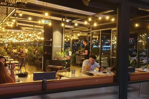 a group of people sitting at a restaurant with lights at Metro House in Site, Next to the Shopping Mall in Sarıgazi