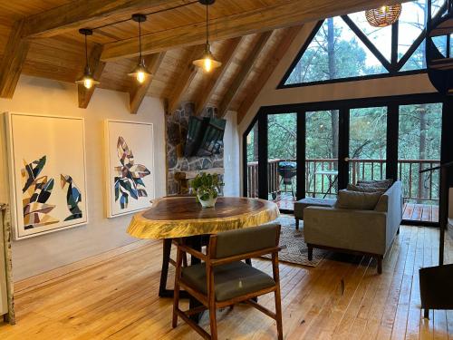 a living room with a wooden table and glass windows at Cabañas VIP Mazamitla in Mazamitla