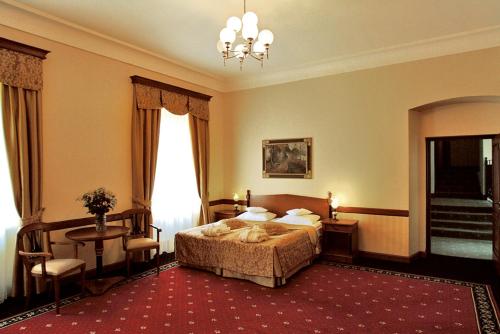 a bedroom with a bed and a table and chairs at Zamek Na Skale in Trzebieszowice