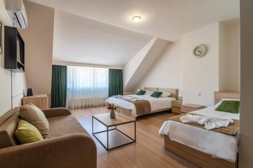 een woonkamer met 2 bedden en een bank bij New Tiflis Apartment Mziuri in Tbilisi City
