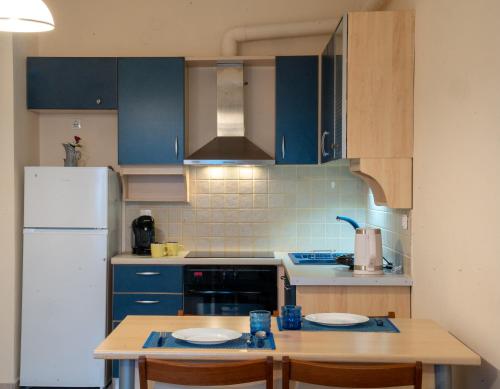 eine Küche mit blauen Schränken und einem weißen Kühlschrank in der Unterkunft Delphian Colors - Blue Edition in Delphi