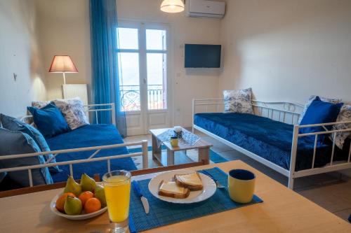ein Wohnzimmer mit Sofa und Tisch mit Essen drauf in der Unterkunft Delphian Colors - Blue Edition in Delphi