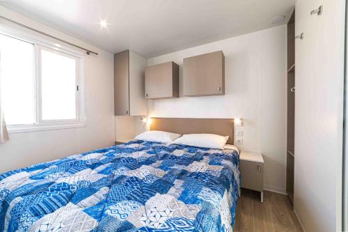 a bedroom with a blue and white bed and a window at Centro Turistico San Nicola in Peschici