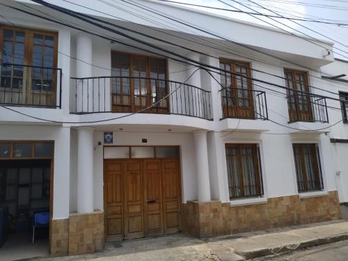 biały dom z drewnianymi drzwiami i oknami w obiekcie White House - Casa de interacción. w mieście Sucre