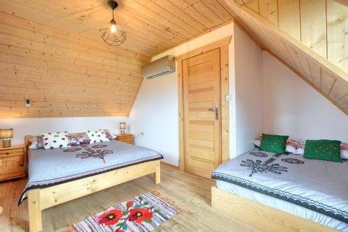 a bedroom with two beds in a log cabin at Góralski Domek Tomek in Ciche