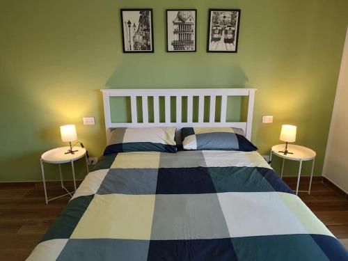 a bedroom with a large bed with two tables at Accogliente bilocale comodo per aeroporto e centro in Caselle Torinese