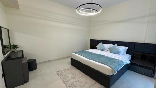 een slaapkamer met een bed en een kroonluchter bij EasyGo - Polo Residence 1 Bedroom Community View in Dubai