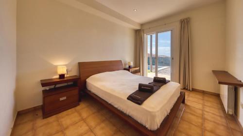 Habitación de hotel con cama y ventana grande en Costacabana - Villa Mauri, en Blanes
