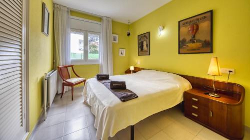 1 dormitorio con 1 cama, 1 silla y 1 ventana en Costacabana - Villa Miro, en Lloret de Mar