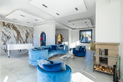- un salon avec des chaises bleues et un piano dans l'établissement Luxurious Villa with heated pool 6BR-12p - Cannes, à Cannes