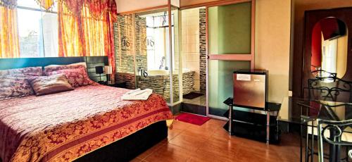 ein Schlafzimmer mit einem Bett und ein Badezimmer mit einem Waschbecken in der Unterkunft hostal keymar in Moquegua