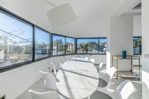 une salle à manger blanche avec une table et des chaises blanches dans l'établissement Luxurious Villa with heated pool 6BR-12p - Cannes, à Cannes