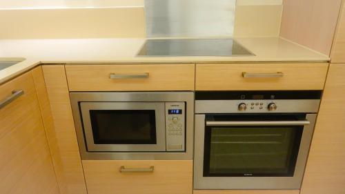 a kitchen with a stove and a microwave at Wood studio flat in London