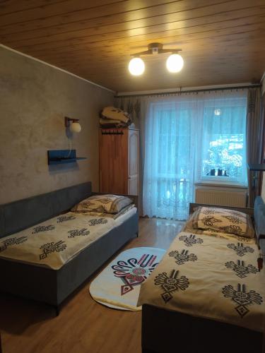 2 camas en una habitación con ventana en Czesławka, en Zawoja