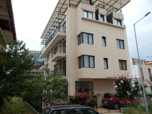 a tall white building with a lot of windows at Flowers Apartments in Nesebar