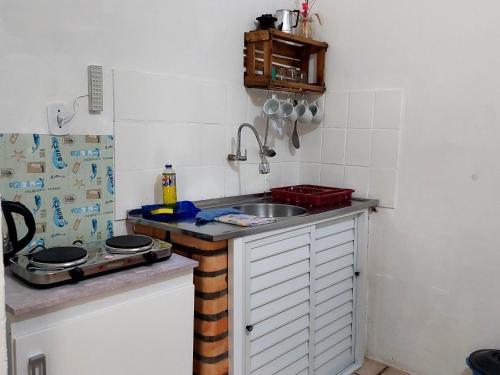 a small kitchen with a sink and a counter at Residencial Bem Estar in Bombinhas