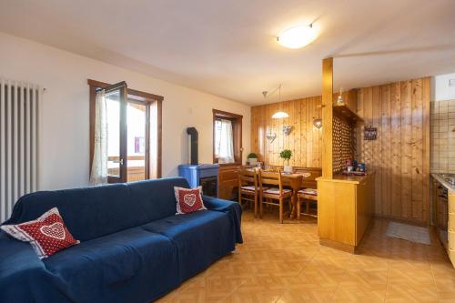 sala de estar con sofá azul y cocina en Ciasa de Vich, en Vigo di Fassa
