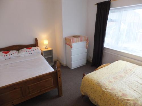 a bedroom with two beds and a window at Exceptional Rated 10, 15 mins from East Croydon to Central London, Gatwick - Spacious, Sleeps up to 16 plus Cot - Free WiFi, Parking - Next to Lloyd Park, Great for Walkers - Ideal for Contractors - Families - Relocators in Croydon
