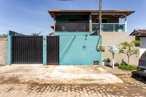 uma casa com um portão azul em frente em Suítes Brisa Tropical em Cabo Frio