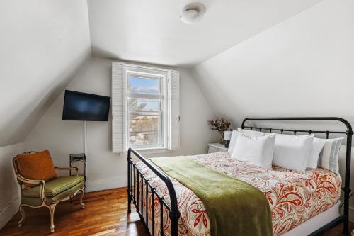 a bedroom with a bed and a chair in a attic at The Cozy Villager in Stowe