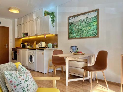 een keuken met een tafel en stoelen in een kamer bij Sunny studio close to the slopes in Borovets