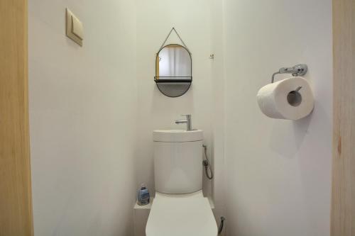 a white bathroom with a toilet and a roll of toilet paper at Góralski Domek Tomek in Ciche