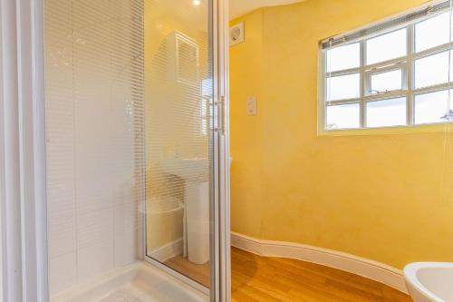 a bathroom with a shower and a sink at Corner Cottage - The Pink House in Southwold