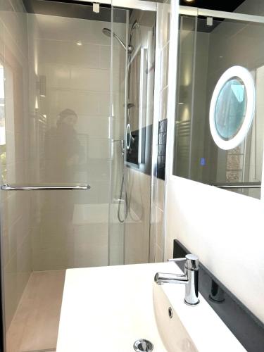 y baño con ducha, lavabo y espejo. en STUDIO AVENUE, en Remiremont