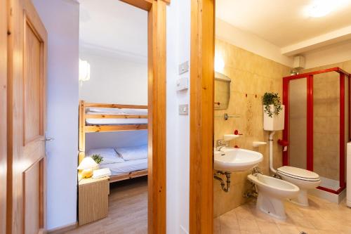 a bathroom with a toilet sink and a bunk bed at Ciasa de Vich in Vigo di Fassa