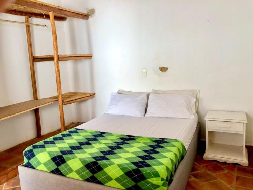 a bedroom with a bed with a checkered blanket at Casa Caracolí in Villanueva