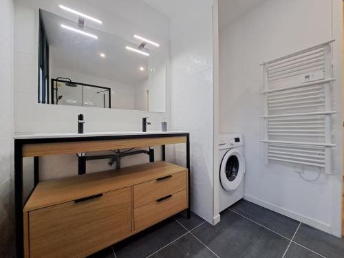 a bathroom with a sink and a washing machine at Antibes, duplex lumineux in Reims