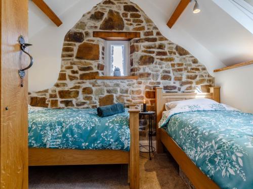 a bedroom with a stone wall at 2 Bed in Bishops Tawton 79393 in Bishops Tawton