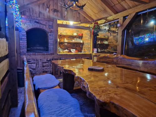 a dining room with a wooden table and a fireplace at Vodenica Vrelo Chalets in Vrelo Koreničko