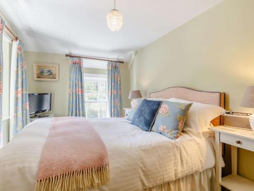 um quarto com uma cama branca e almofadas azuis em 2 Bed in Talybont-on-Usk BN249 em Talybont
