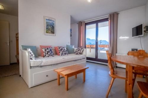 uma sala de estar com um sofá e uma mesa em Flat with a view in Huez - Welkeys em LʼHuez
