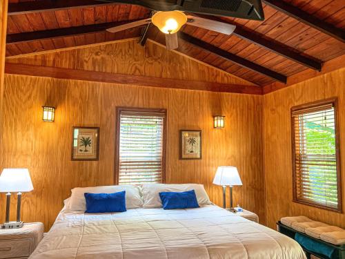 a bedroom with a large bed with blue pillows at Sunset Cove Beach Resort in Key Largo