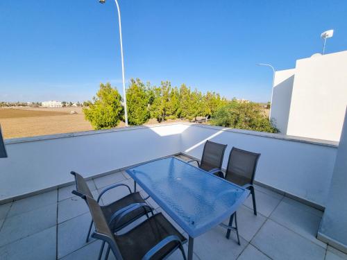 una mesa azul y sillas en el balcón en Beach Villa With Private Pool And BBQ en Lárnaca