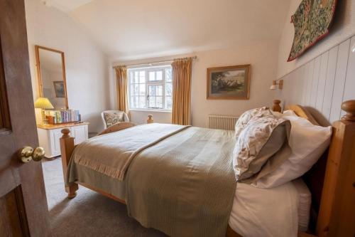 Schlafzimmer mit einem Bett und einem Fenster in der Unterkunft Acorn Cottage in Bolton Bridge