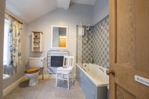 a bathroom with a toilet and a tub and a sink at Acorn Cottage in Bolton Bridge