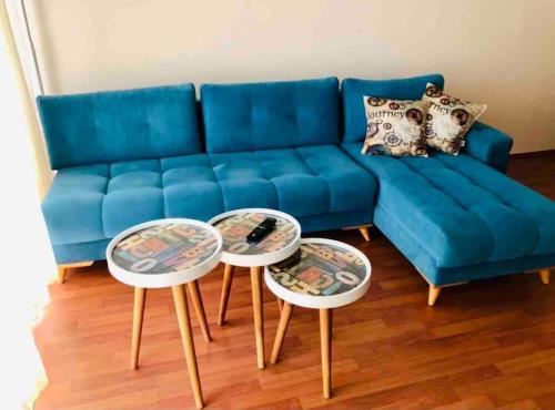a blue couch with two tables in a living room at Choice of Satisfaction in a Quality Neighborhood in Istanbul