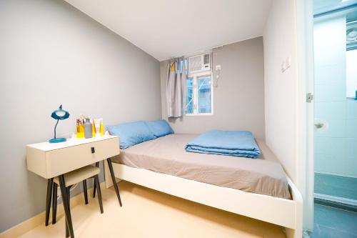 um pequeno quarto com uma cama e uma secretária em Student Accommodation - 292 Hennessy Road em Hong Kong