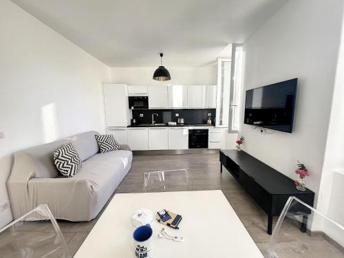 un salon blanc avec un canapé et une télévision dans l'établissement Cosy 1BR Cannes Gambetta hyper centre - Croisette 1 mn - 4 pers by Olam Properties, à Cannes