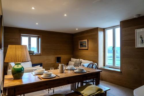 a dining room with a table and a couch at The Hayloft at Lower Hurst Farm in Hulme End