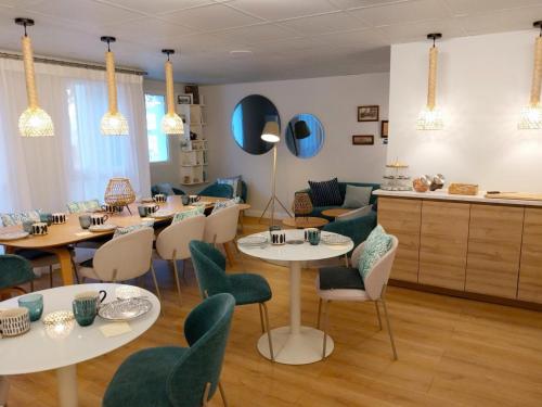 a restaurant with tables and chairs in a room at Séjours & Affaires La Rochelle Les Minimes in La Rochelle