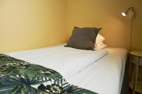 a bed with a pillow on it in a room at Hotel Svea, BW Signature Collection in Simrishamn